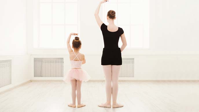 バレエを習う小さな女の子と教える女性の後ろ姿