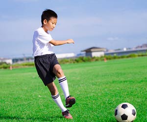 サッカーボールを蹴る少年