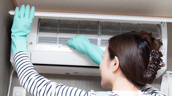 エアコンを掃除する女性